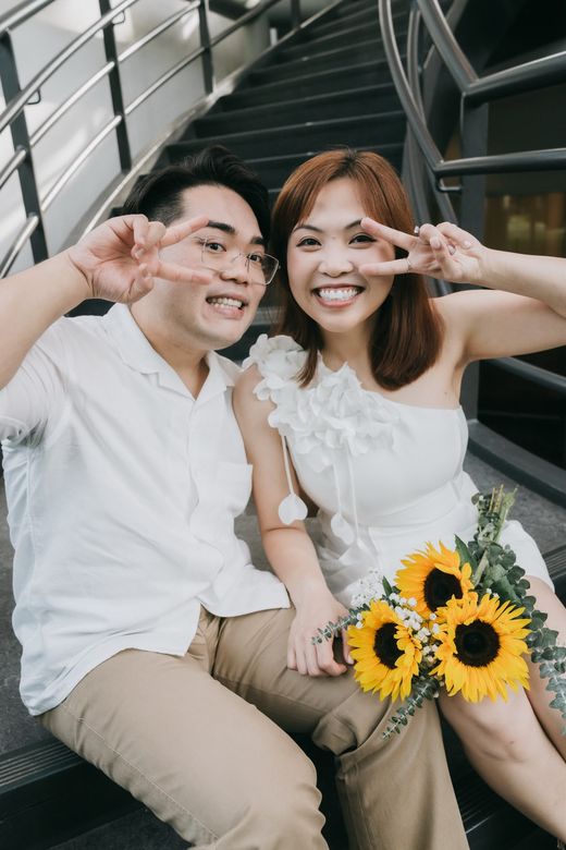Richard and Mabel making peace signs at the camera on a staircase