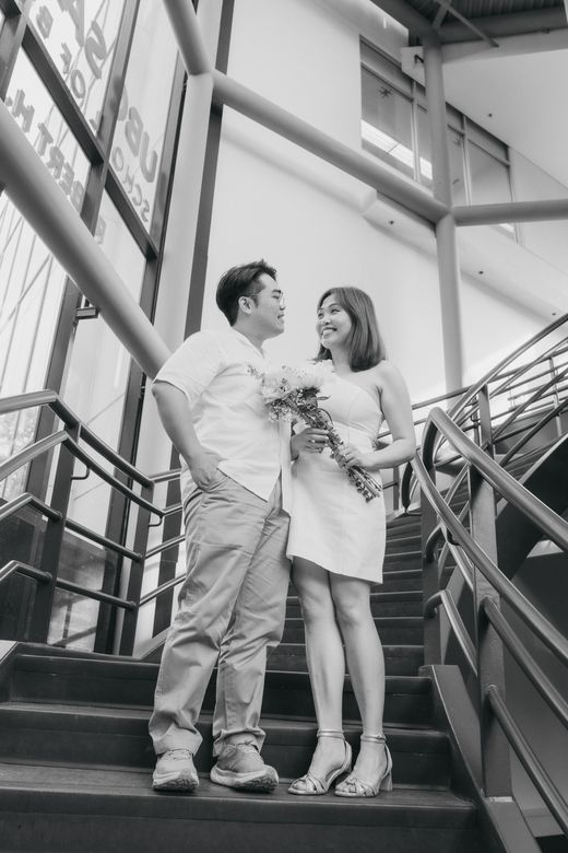 Black and white photograph of Richard and Mabel smiling at each other on a staircase